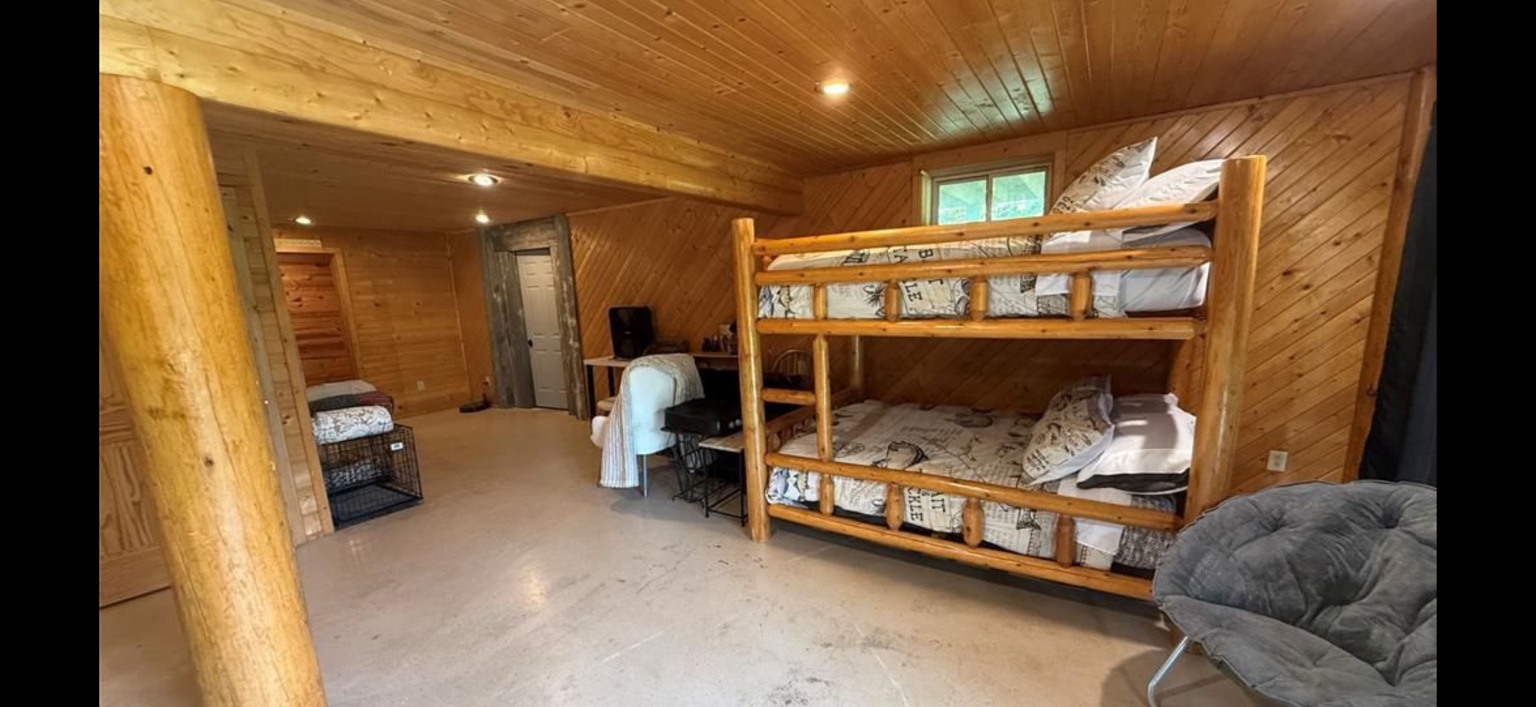 Wood-paneled bunk room with rustic log bunk bed