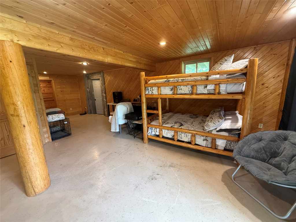 Wood-paneled bunk room with log bunk beds
